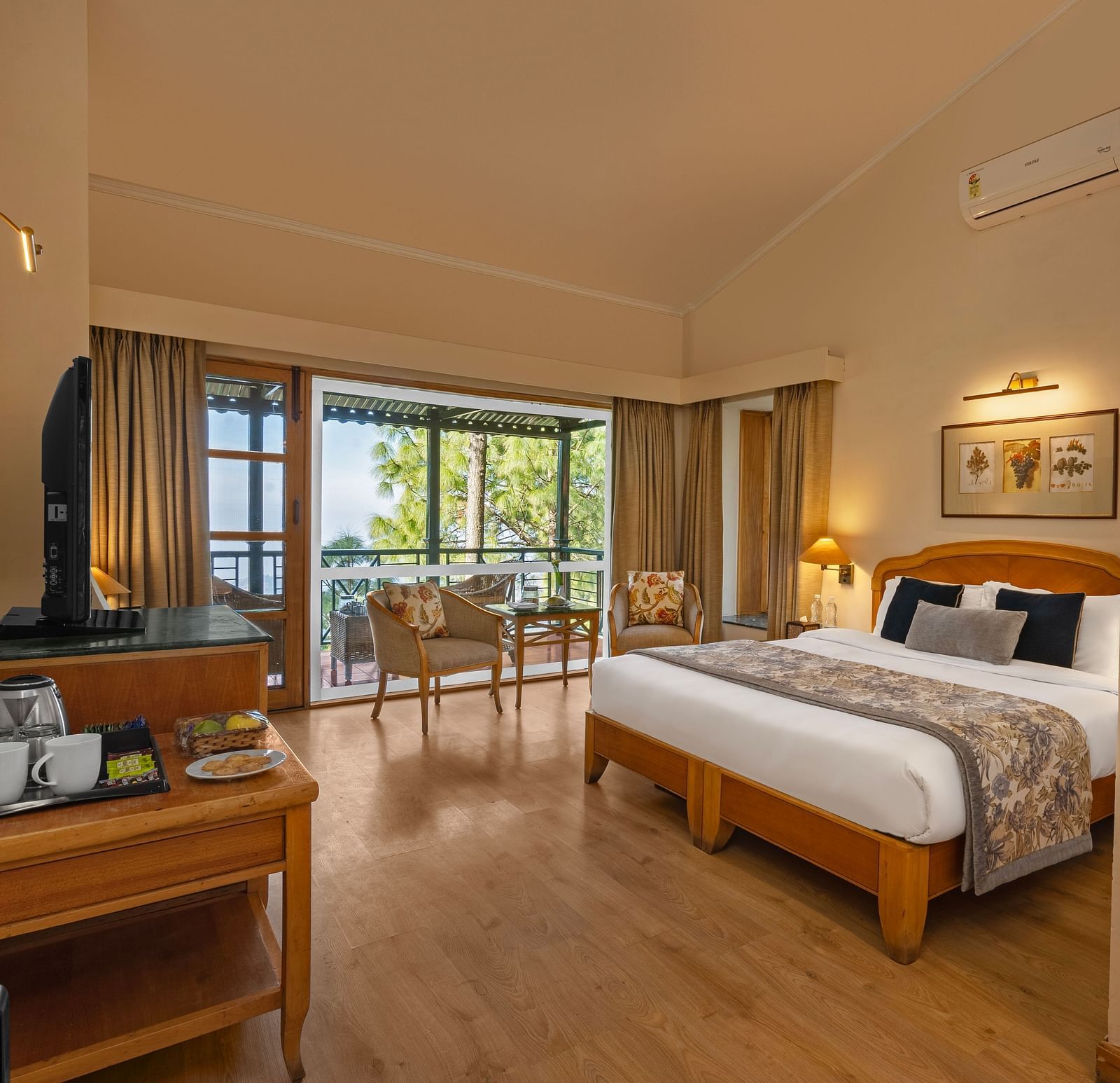 A corner view of Superior Cottage Valley view with comfy bed, table, open window and wall mirror at Baikuth resort, kasauli.
