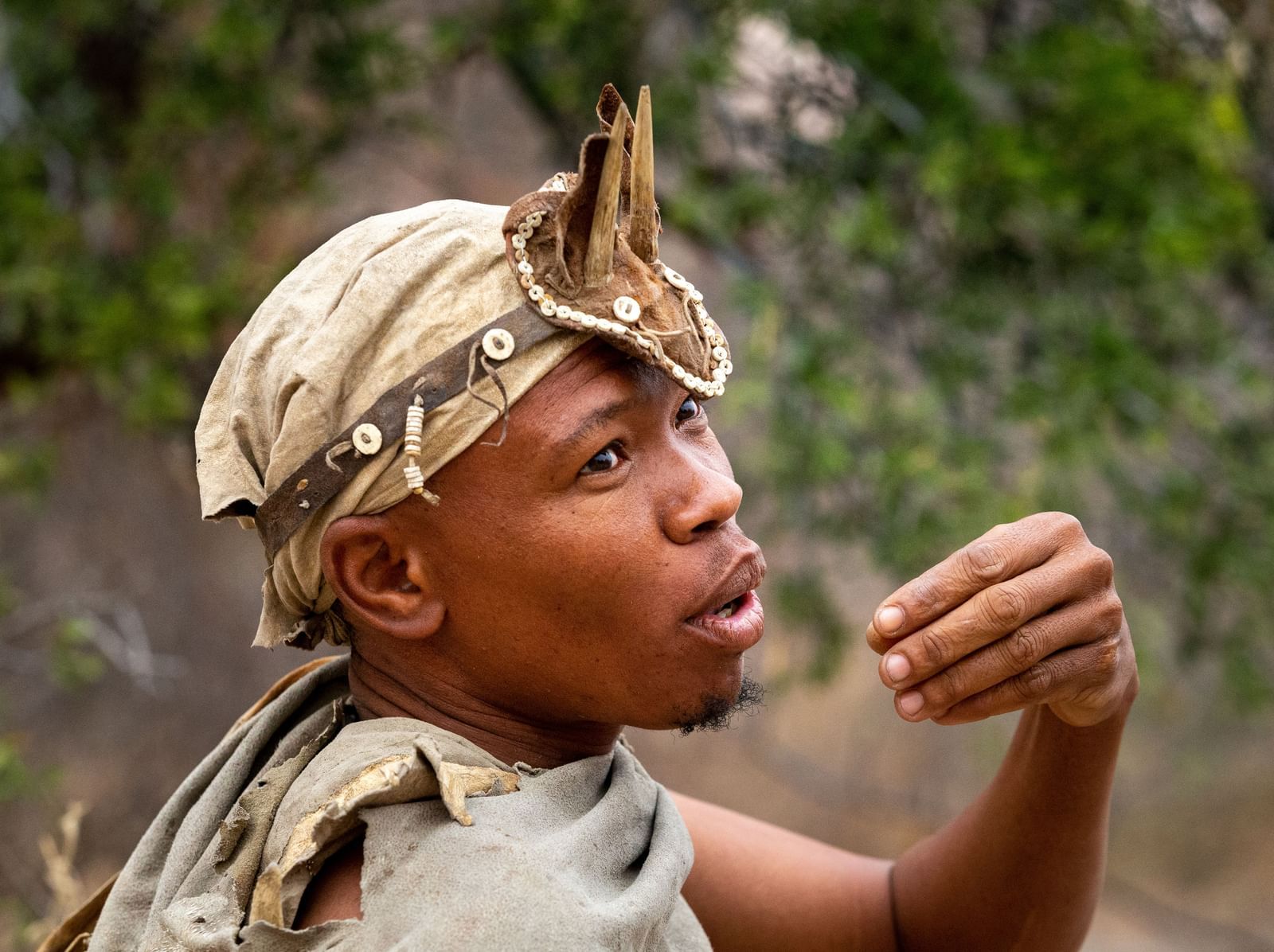 African man in traditional attire and unique headpiece.