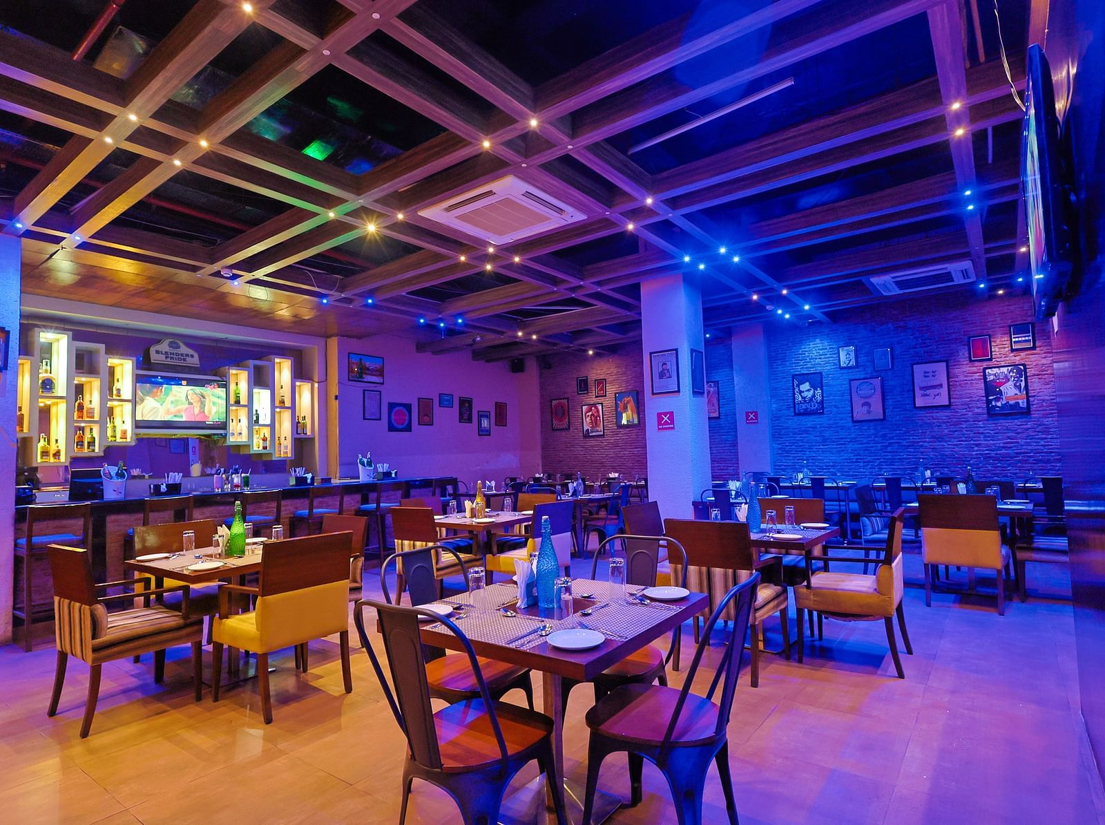  A diagonal view of the restaurant that highlights the ceiling lighting and showcases the spaciousness of the entire setup