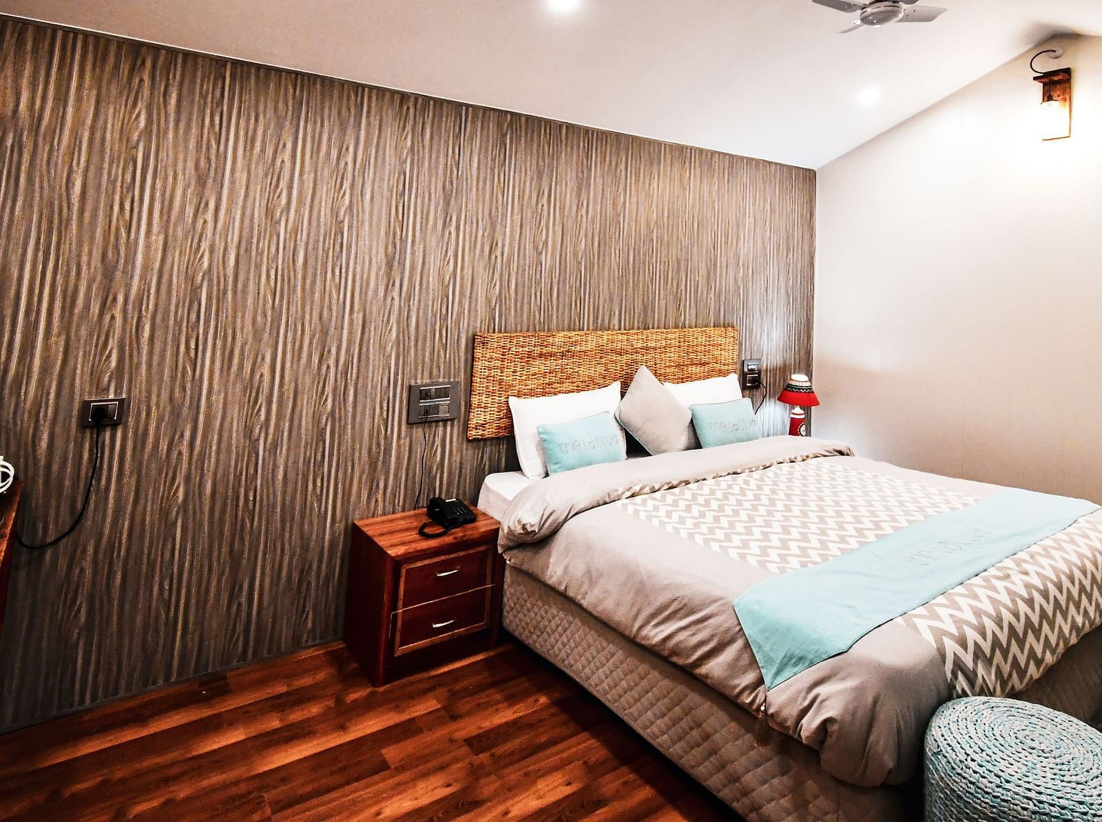 image of the standard room featuring a double bed in the corner with wooden flooring - The Tattva Boutique Resort