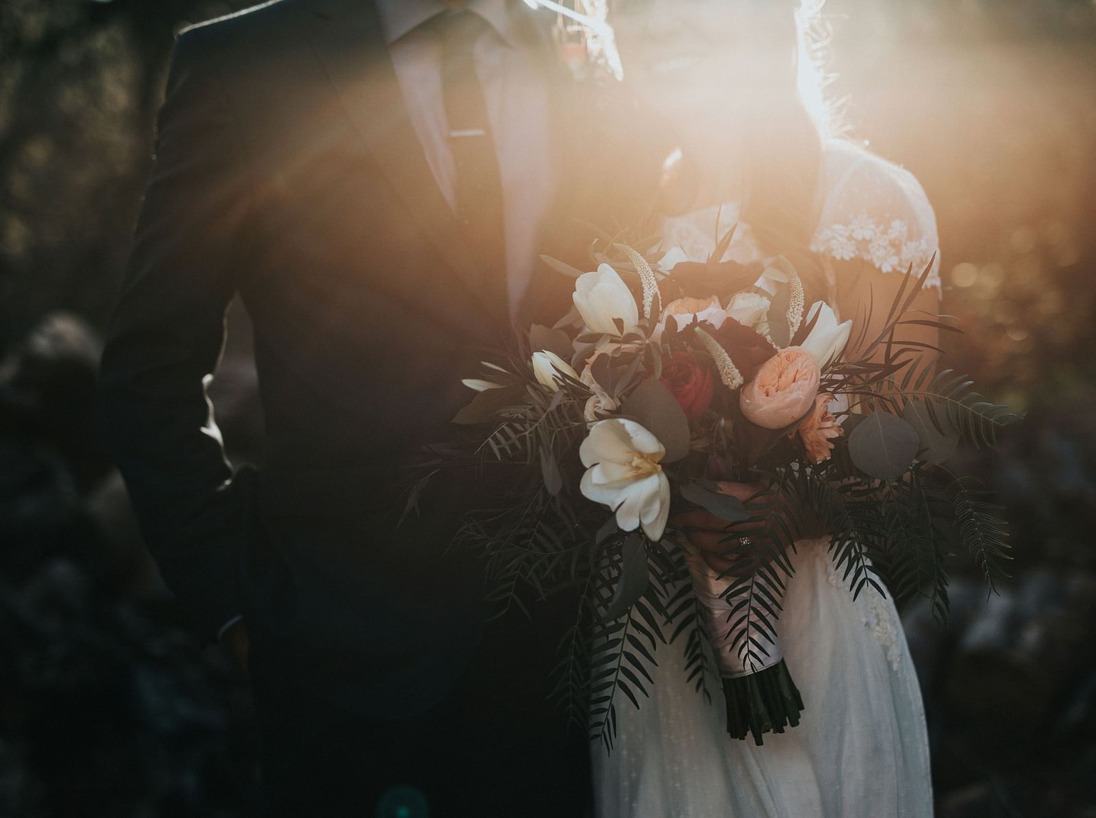 An image of a couple standing amid lush greenery
