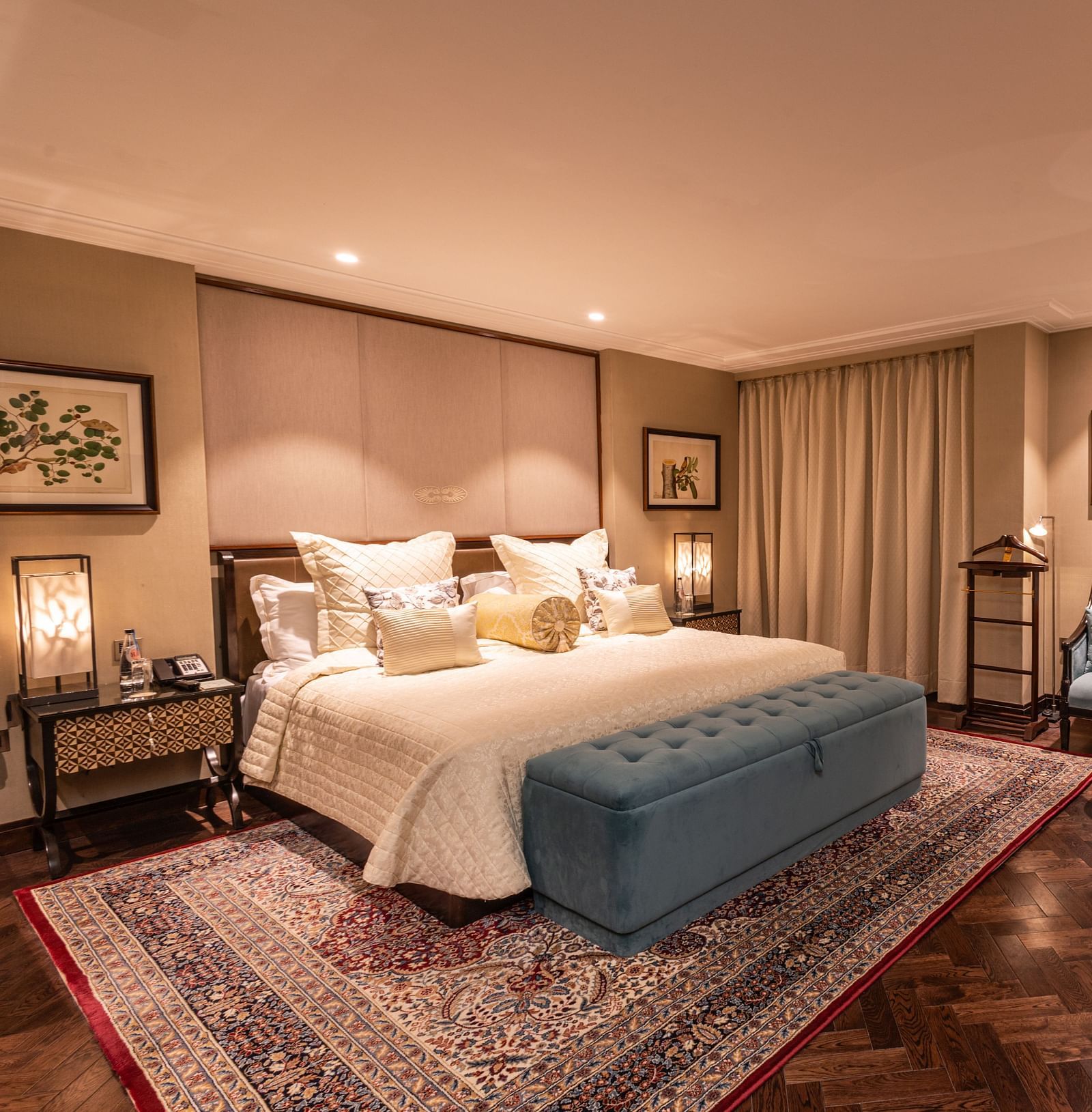 Luxury King Bed Room at The Claridges New Delhi, featuring a cosy king sized bed with plush pillows, bedside lamps, and a sofa seating area in the corner