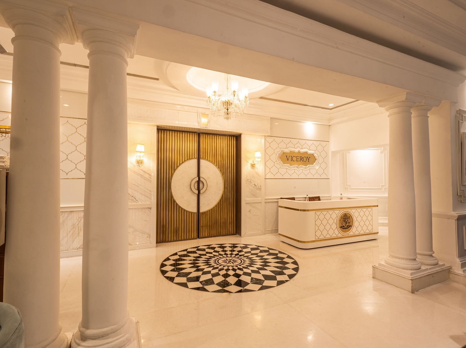 Image featuring the Viceroy Hall event venue at The Claridges New Delhi, showcasing the doorway, reception in the corner, and an elegant chandelier hanging