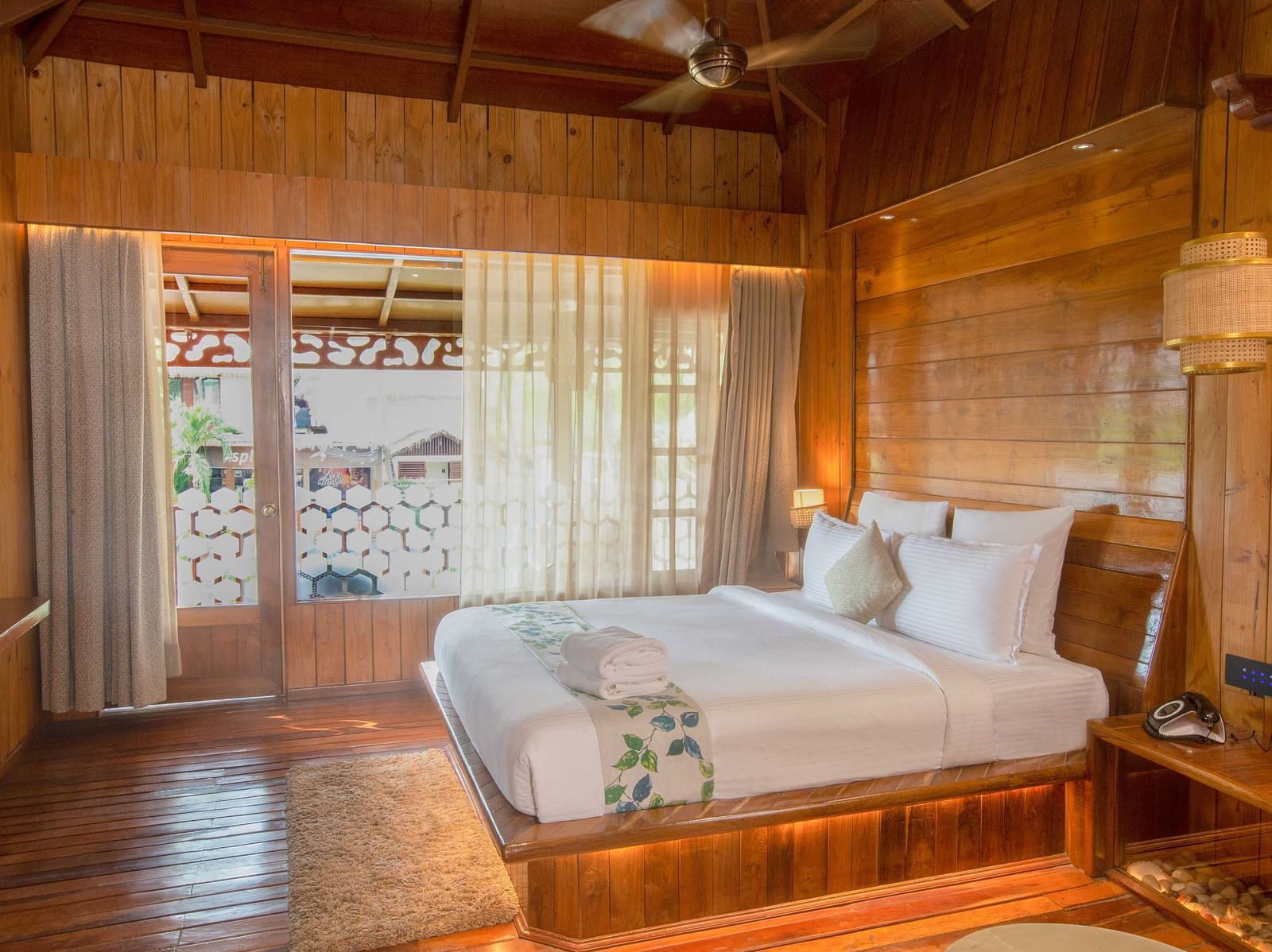 Image of Coral Turquoise at Coral Reef Resort and Spa in Havelock featuring a plush bed on the wooden furnished floor next to the door to the balcony