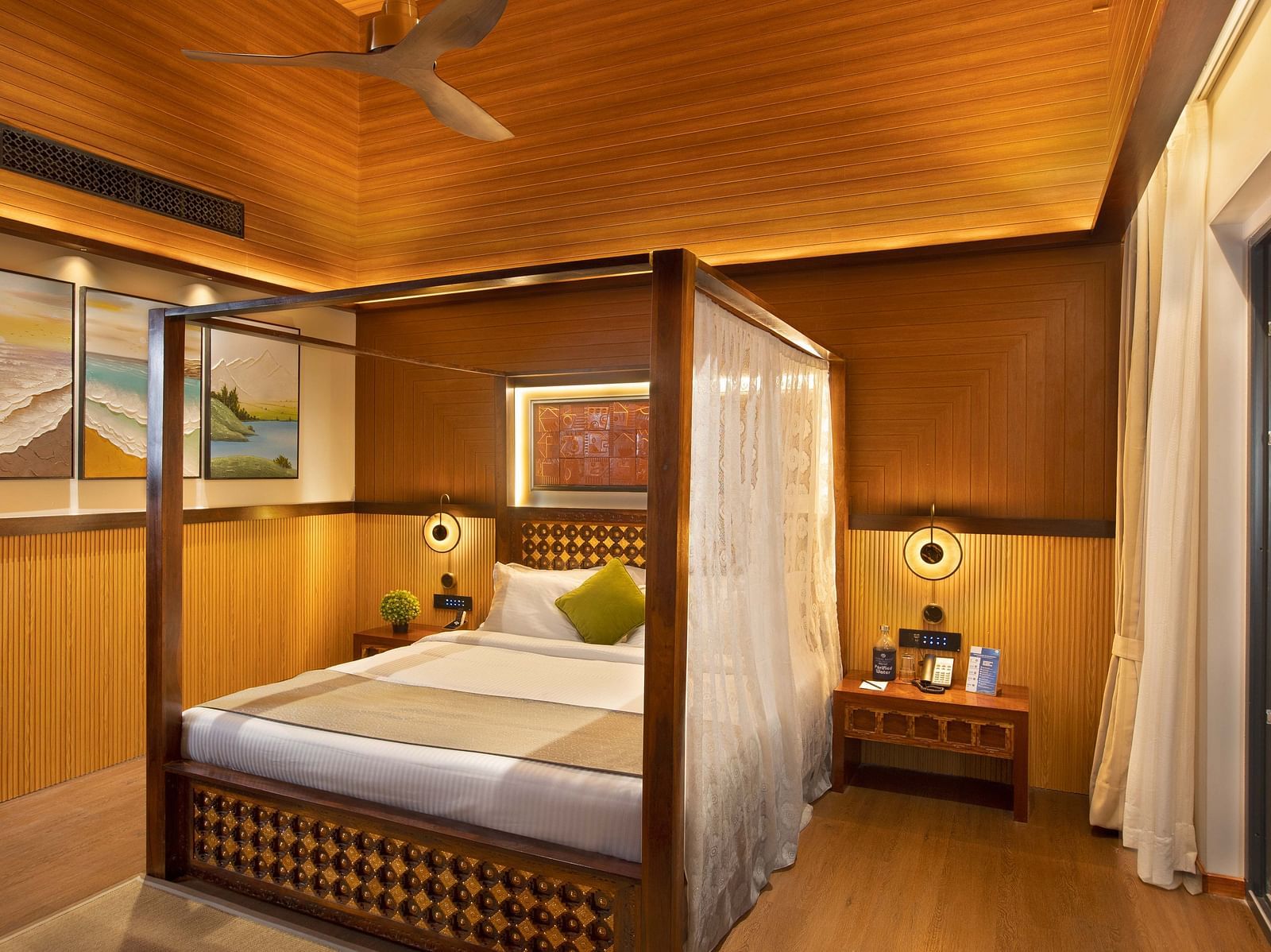 Coral Teal Suite at Coral Reef Resort and Spa in Havelock featuring a plush canopy bed with a nightstand next to it and a lamp over it
