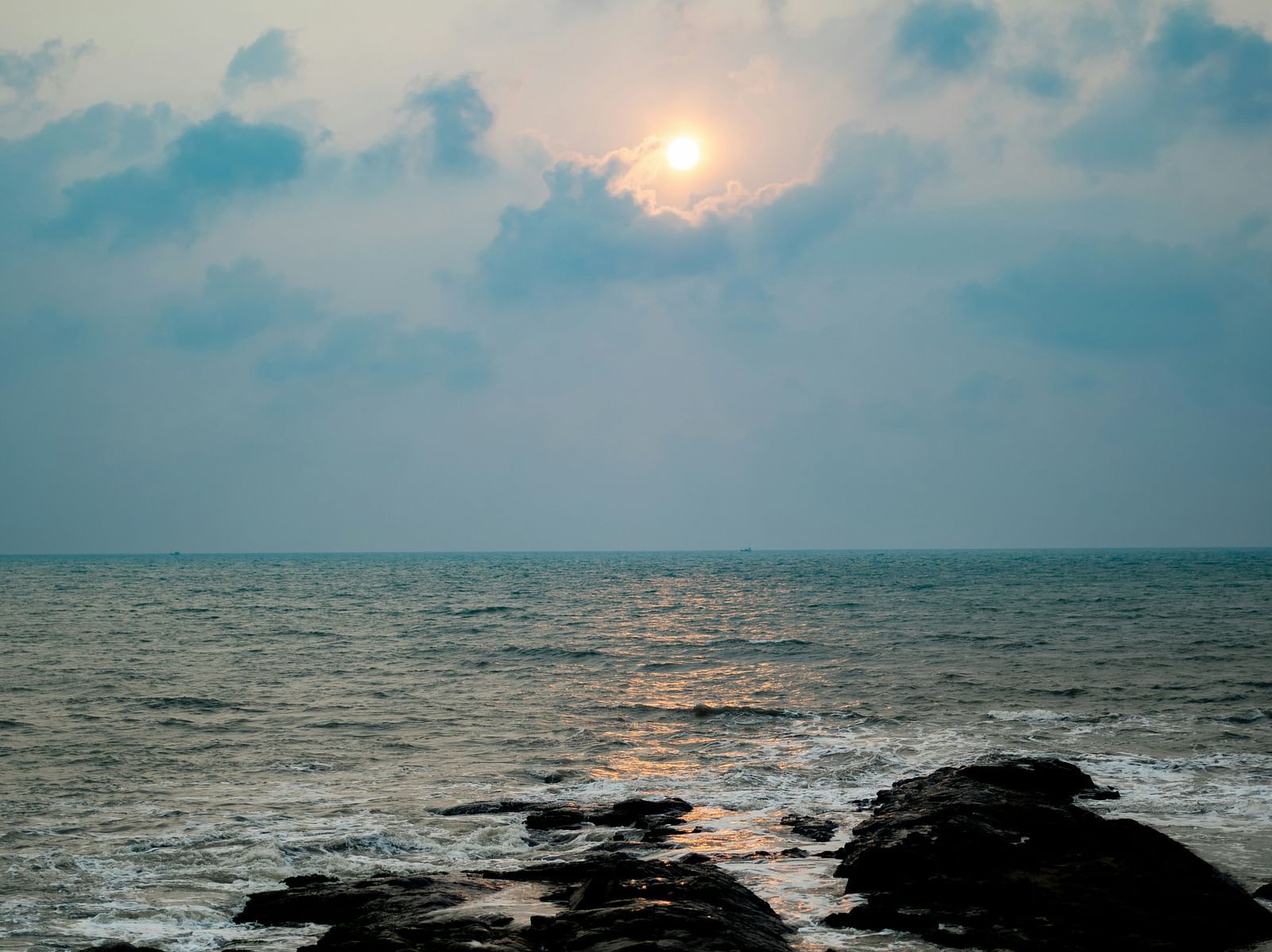 An overview of Anjuna Beach with the sun setting in the background