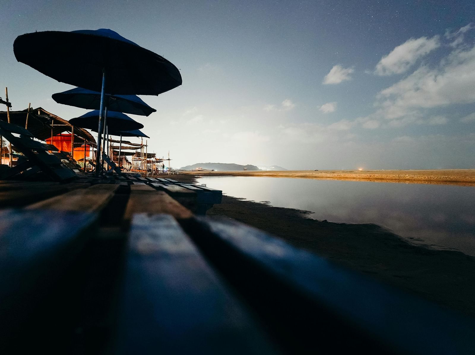 Shot of umbrellas at the sea shore with a background of setting sun.