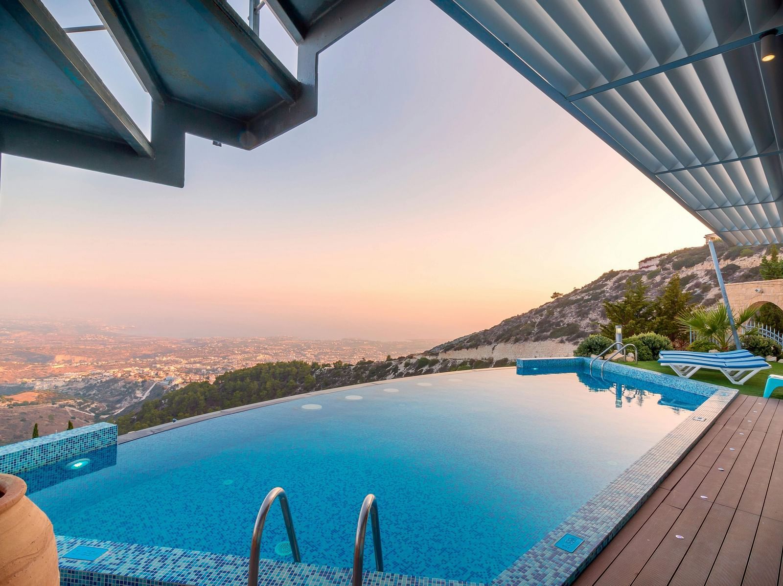 An image of an infinity pool on a rooftop with the backdrop of a clear sky