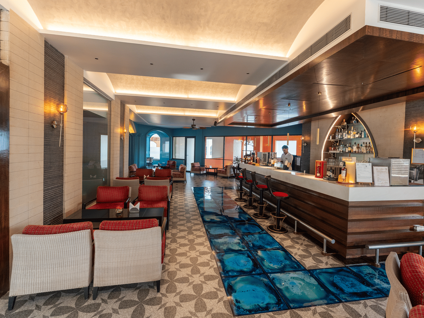 Stylish indoor bar lounge with plush seating and blue carpet at Kenilworth Resort & Spa, Goa.
