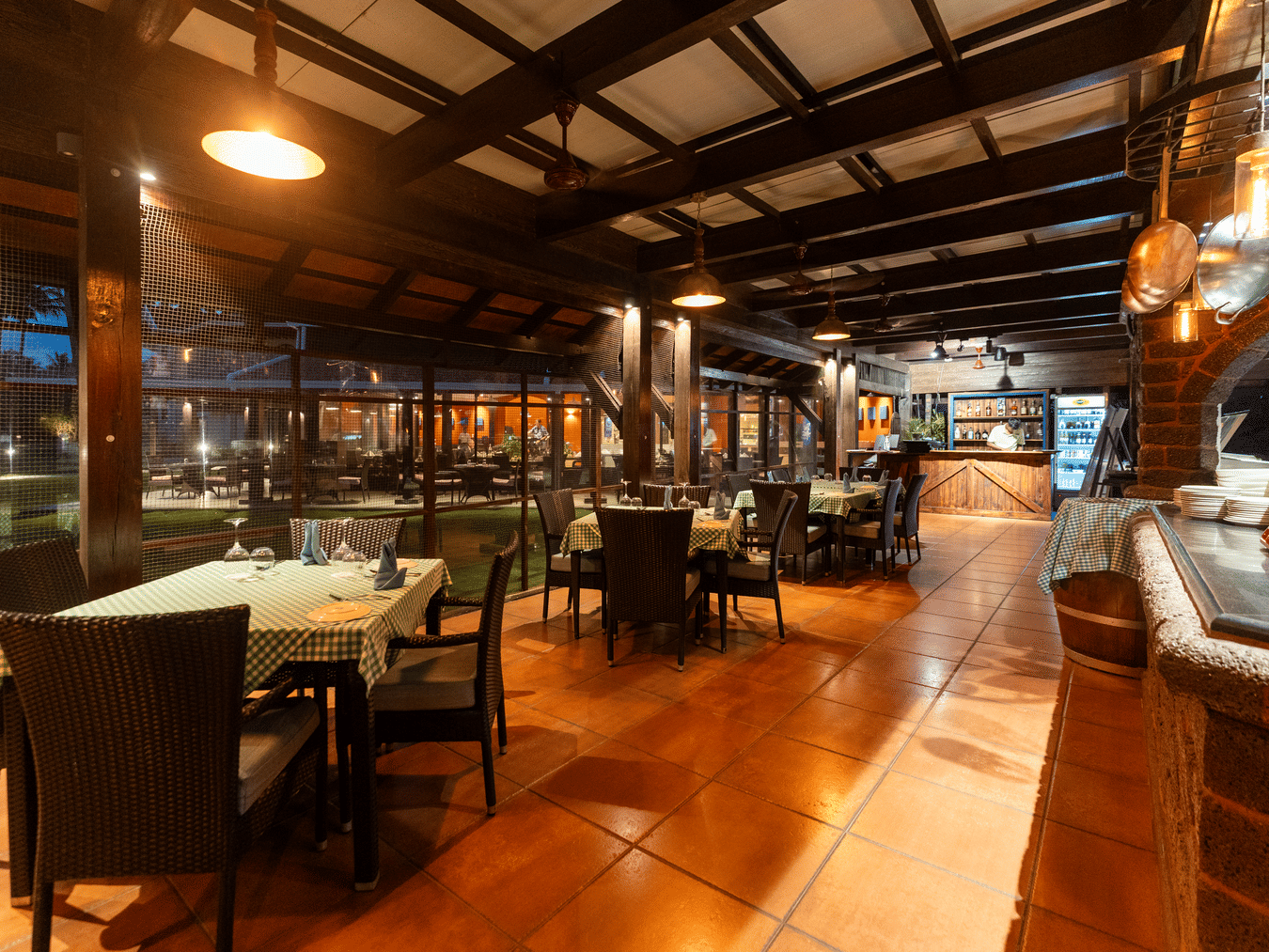 Warmly lit open-air restaurant featuring covered patio seating at Kenilworth Resort & Spa, Goa.