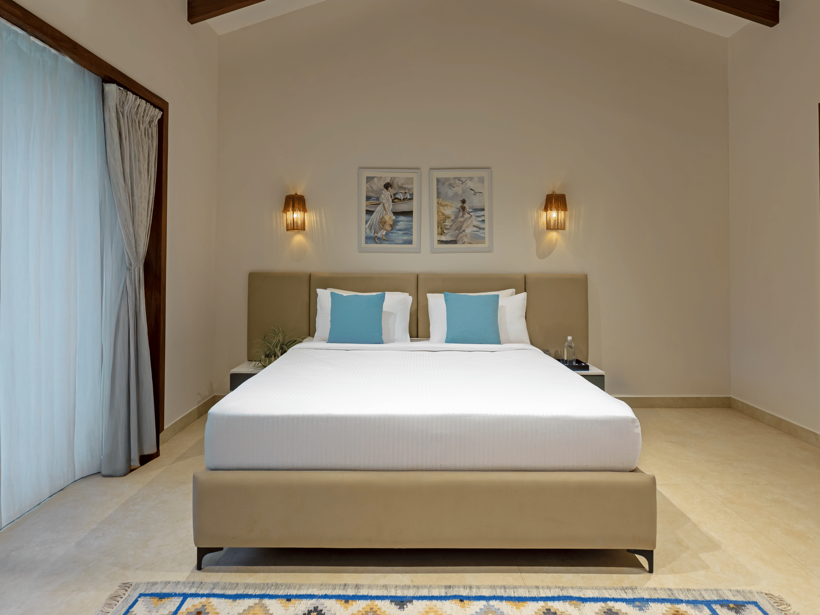 Spacious deluxe room with king bed, warm lighting, and minimal decor at Lamrin Morjim Goa.