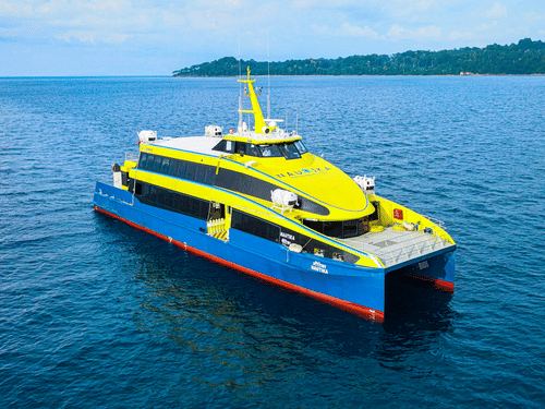 A ferry travelling on the ocean with an island in the background, one of the travel options for romantic getaways near Chennai.