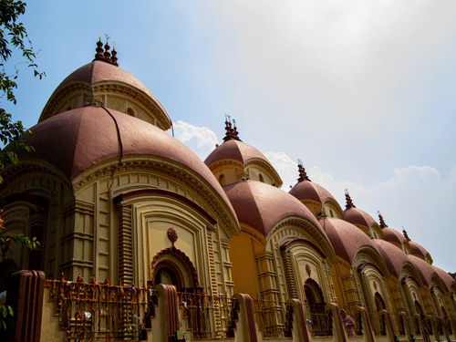 a facade view of the famous Dakshineswar Kali Temple with pagoda shaped roofs captured during the day.