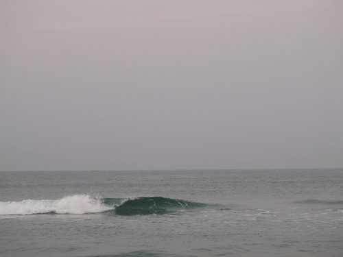Waves against a grey sky crashing on Benaulim Beach in Goa