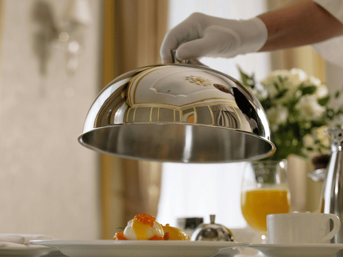 a person lifting a covering from food