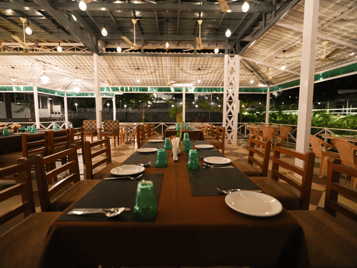 Picture featuring the restaurant, with dining tables arranged and brightly lit.
