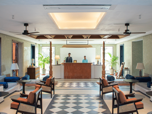 The hotel's reception area featuring a checkered floor, two receptionists, and a warm, welcoming ambiance.