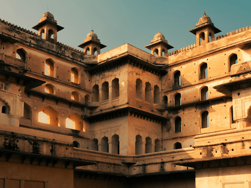 A large historic building with multiple windows, balconies, and a courtyard structure.