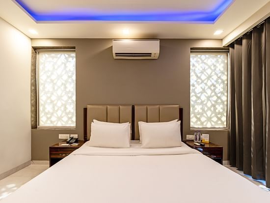A hotel room with ambient lighting and a wall-mounted split A/C at Hotel Bawa, Gurgaon.