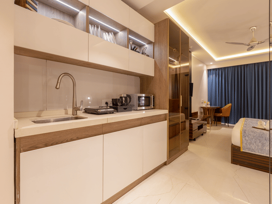 Close-up of a premium kitchenette featuring a modern faucet, white countertops, and warm lighting.