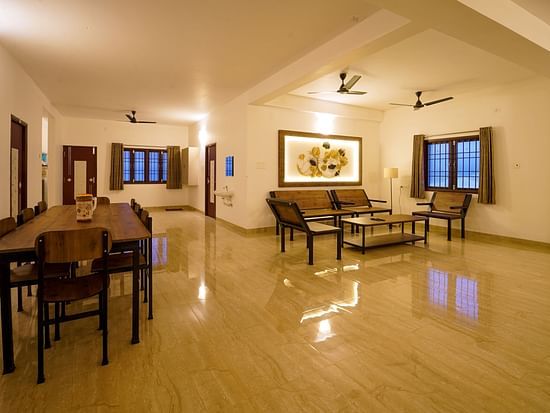 Living area with seating arrangements of sofas and coffee table and dinign area inside Superior Villa - La Tamara Luxury, Pondicherry