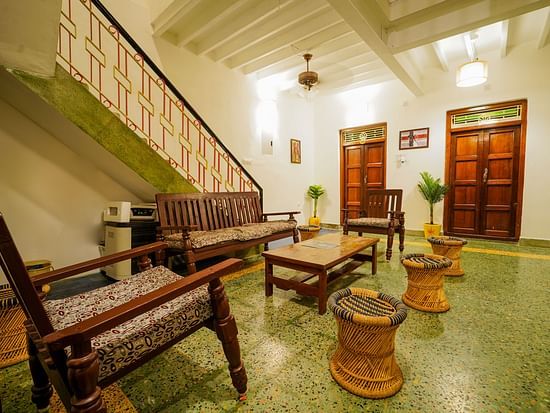 The living area with sofas and a coffee table and steps leading to the 1st floor inside superior villa - La Villa Heritage, Pondicherry