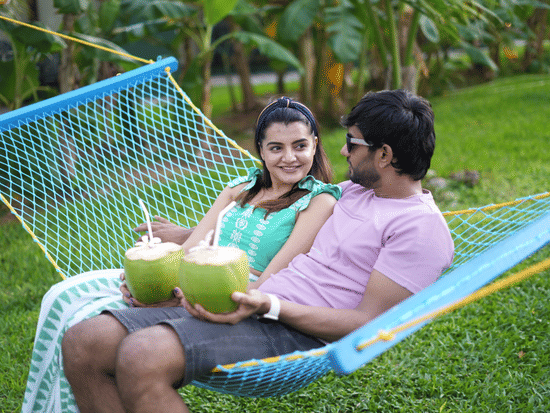 A man and a woman sitting on a hammock