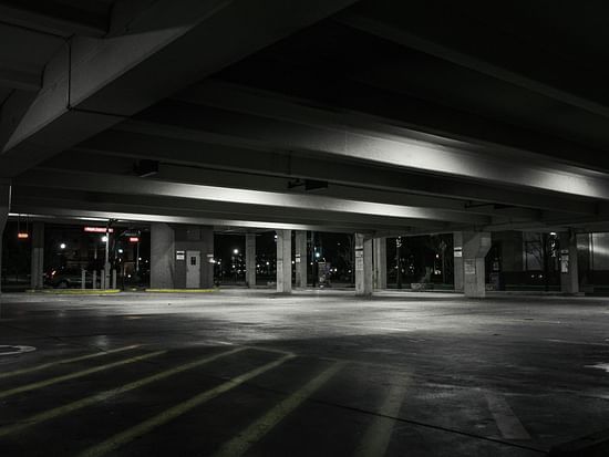 An image of an empty parking garage, dimly lit by lights