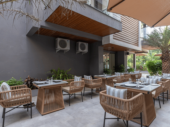 Outdoor courtyard café with rattan seating and dining tables set for outdoor dining at Sibaya Courtyard By Stone Wood Premier.