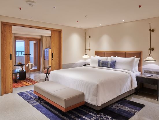  Image of a bedroom with a king size bed and a bed bench in front of it - The Dukes Retreat, Khandala