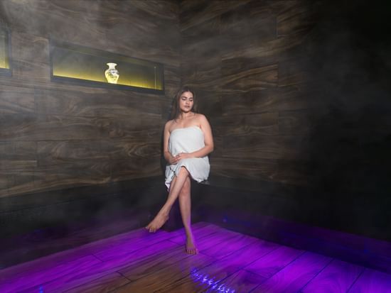 An image of a woman sitting in a counter top of a Sauna Room -  The Manor Luxury Apartments, Shimla
