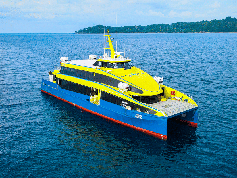 A ferry travelling on the ocean with an island in the background, one of the travel options for romantic getaways near Chennai.