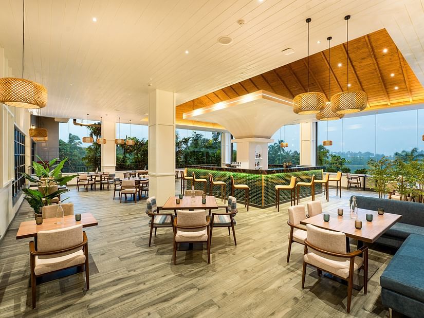 A diagonal view of the rooftop dining area showcases warm lighting and neatly arranged tables and chairs, creating a welcoming ambience for guests at Cloud9 Sarovar Premiere, Palolem Goa