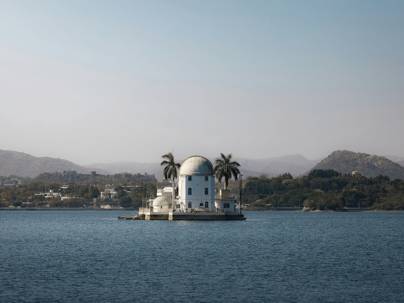 Udaipur Solar Observatory on island in Fateh Sagar Lake Udaipur surrounded by calm waters and distant Aravalli hills under clear sky