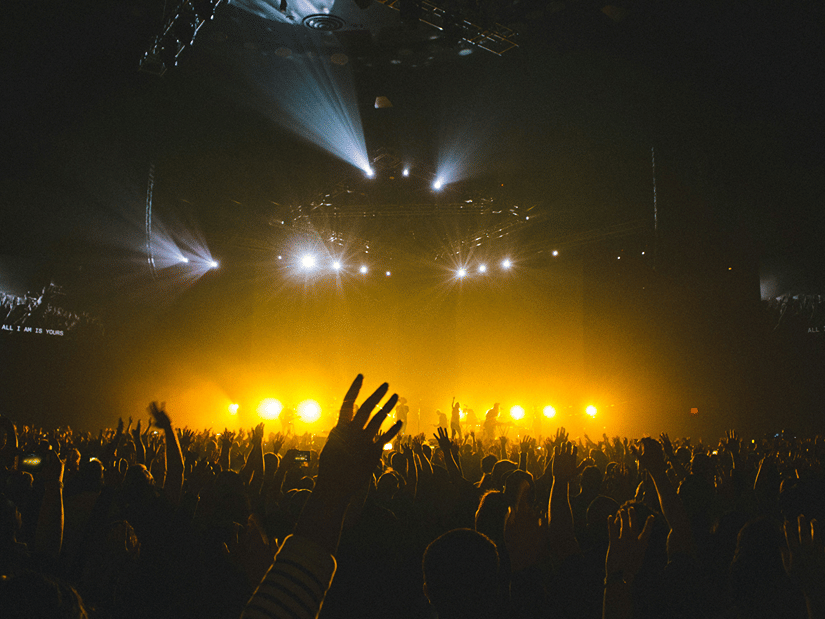 lights shining on the audience from the stage of a music concert