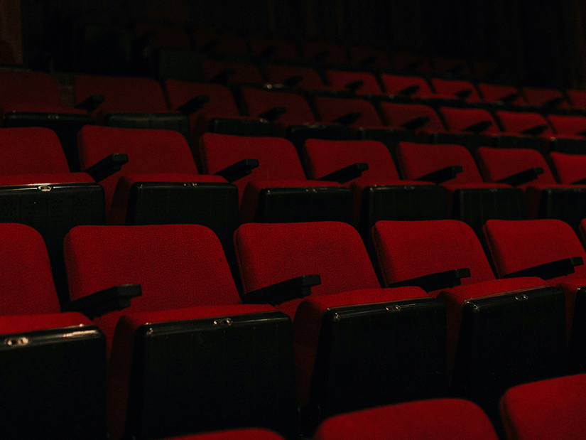 A dimly lit cinema hall featuring rows of empty seats, available for families wanting to go for movies at INOX Quest Mall, Kolkata