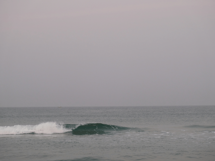 Waves against a grey sky crashing on Benaulim Beach in Goa