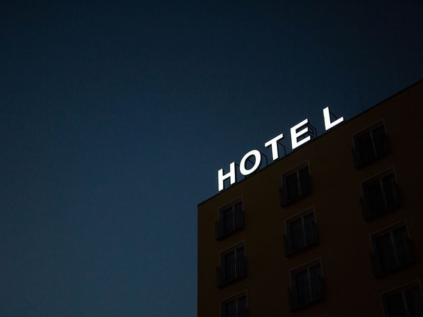 Facade of a hotel in the evening with the signage Hotel on the top of the building