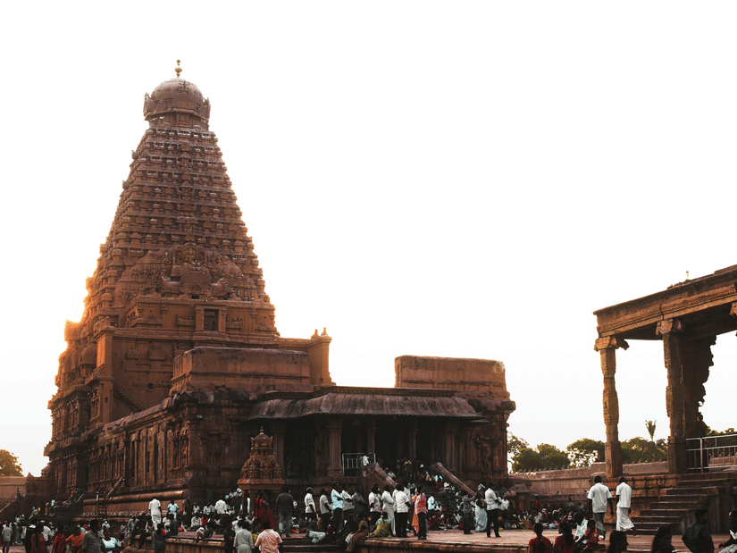 The historic Brihadeeswara Temple in Thanjavur, featuring its massive stone Vimana tower under a bright, hazy sky. It is one of the popular places to visit in Thanjavur for it's architecture.