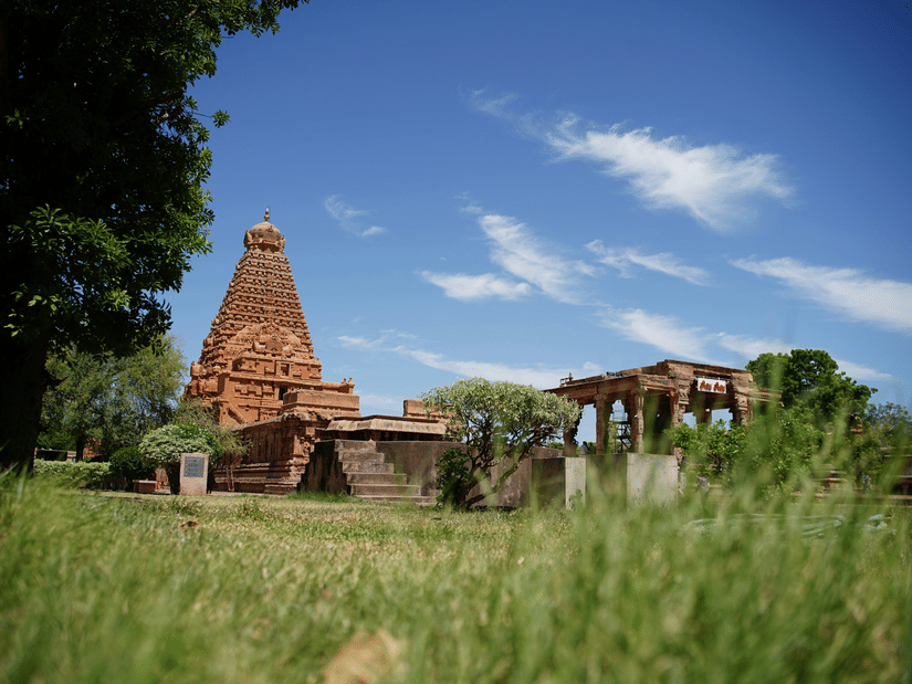 A far out view of Brihadeswara Temple in Thanjavur with green grass in the foreground - Sightseeing in Thanjavur.