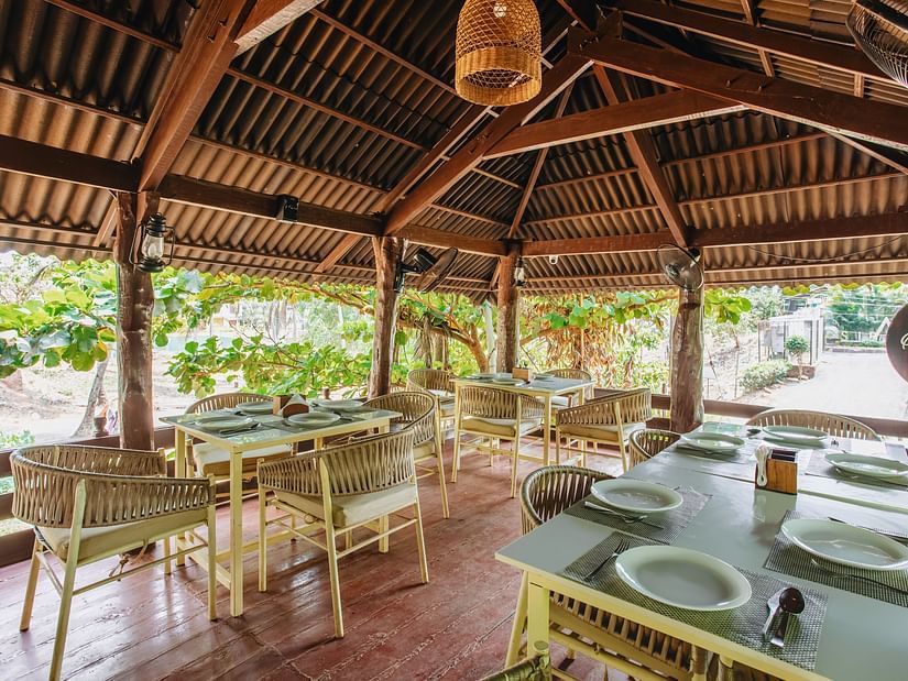 image of the wooden deck with covered seating arrangement surrounded by lush tropical greenery at sibaya beach resort, morjim beach