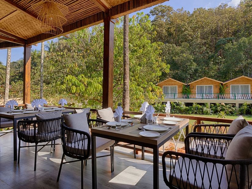 seating arrangements inside al fresco Dining with views outside the restaurant - Stone Wood Jungle Resort, Dandeli