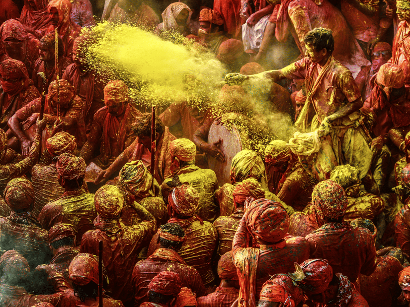 A vibrant scene of Holi celebrations, with people covered in colorful powders and enjoying the festive atmosphere