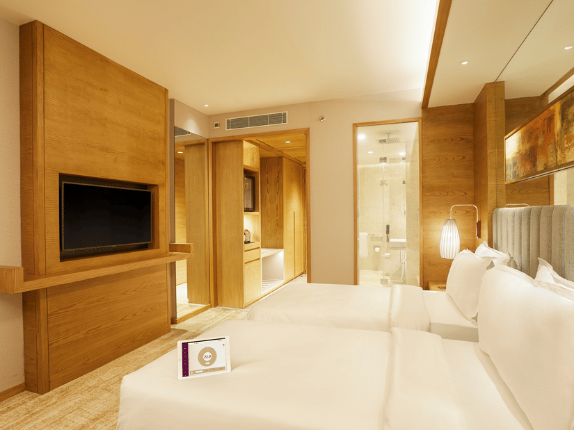 The Side view of Premier Rooms featuring a wall-mounted TV and a bedside light in the corner at The Residency Towers Chennai
