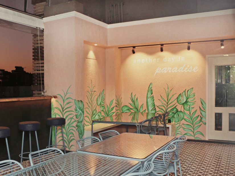 An open air dining area with wooden floor panelling and warm lighting.