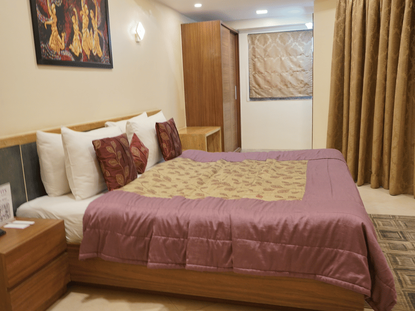 Double bedroom with bedside table and storage units at VITS Kamats Resort, Silvassa