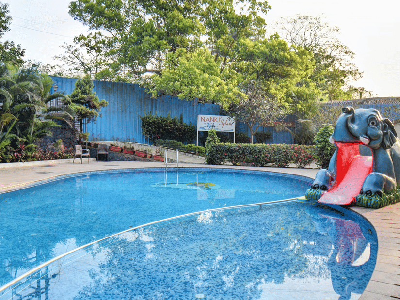 An outdoor swimming pool with a water slide feature at VITS Lonavala.