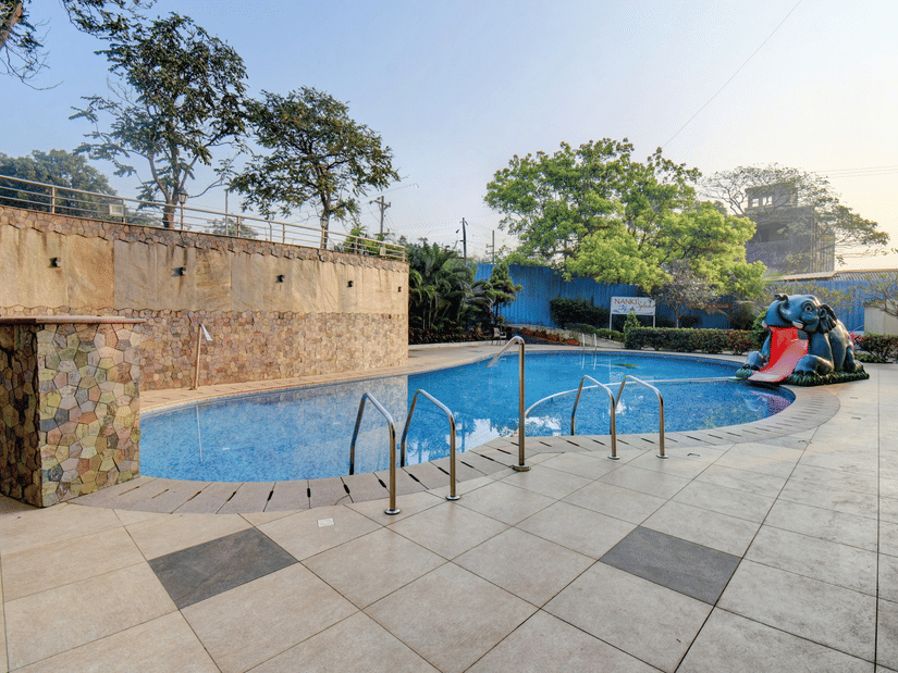 An overview of the swimming pool with lounge space and blue water views at VITS Lonavala.