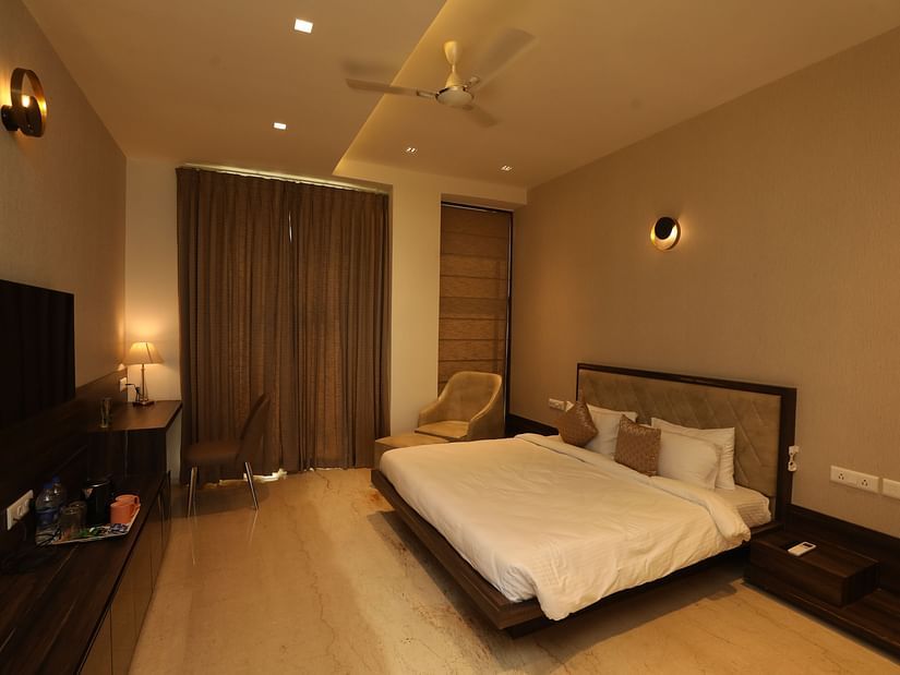 Hotel bedroom interiors with chairs television and a white king size bed