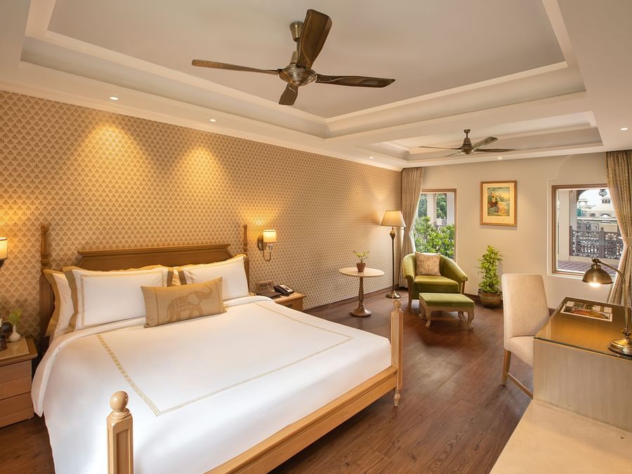 suite in manesar with a comfy king size bed, lavish interiors and wooden flooring at heritage village resort and spa
